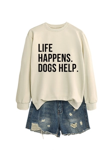 Flat lay of cream crewneck sweatshirt with dog slogan and distressed blue denim shorts
