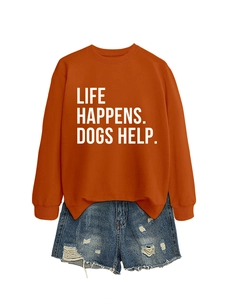 Flat lay of an orange sweatshirt with 'LIFE HAPPENS. DOGS HELP.' text and denim shorts