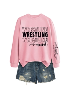 Detail of pink sweatshirt with sleeve text My heart is on that mat and ripped denim shorts