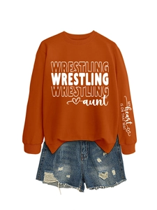 Detail of sleeve print on orange wrestling aunt sweatshirt with denim shorts outfit