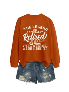 Dettaglio della felpa arancione con scritta Retired e pantaloncini di jeans strappati
