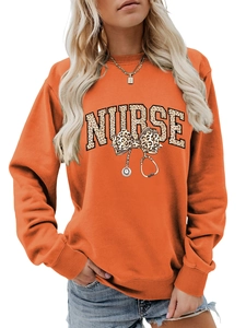 Détail du sweat orange avec texte NURSE en imprimé léopard et motif stéthoscope