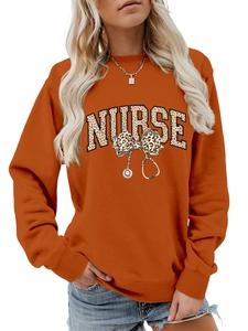 Détail de l'imprimé léopard nurse et stéthoscope sur un sweat orange à col rond