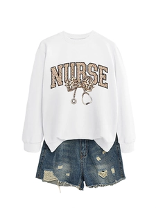 Détail d'un sweat blanc pour infirmière avec nœud léopard et motif de stéthoscope