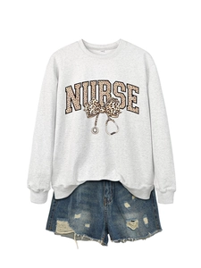 Détail du sweat gris infirmière avec nœud imprimé léopard et motif de stéthoscope