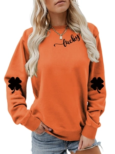 Detail of lucky lettering and black clover print on bright orange sweatshirt sleeves