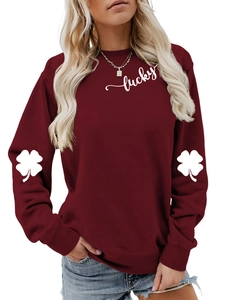 Detail of clover print on sleeves and lucky text on a burgundy crewneck sweatshirt