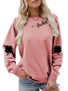 Detail of pink sweatshirt featuring black lucky script and clover prints on sleeves