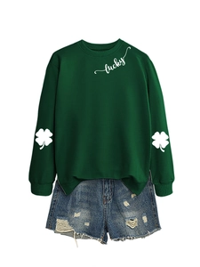 Detail of lucky text and clover print on dark green sweatshirt with ripped denim shorts