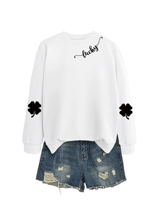 Detail view of white lucky clover sweatshirt and distressed denim shorts layout