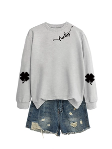 Detail of grey sweatshirt with lucky text and blue distressed denim shorts set