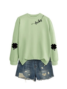 Detail of light green sweatshirt featuring black lucky script and clover sleeve prints