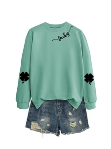 Detail of mint green sweatshirt featuring black lucky script and clover print on sleeves
