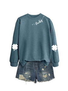 Detail of the white four-leaf clover print on sleeves and Lucky text on gray-blue sweatshirt