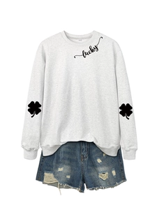 Detail of gray sweatshirt with lucky script print and clover pattern on sleeves