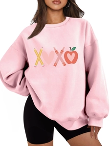 Detail of pink sweatshirt featuring XOXO pencil and heart graphic print
