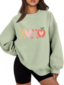 Detail of creative XOXO pencil and heart graphic print on light green oversized sweatshirt