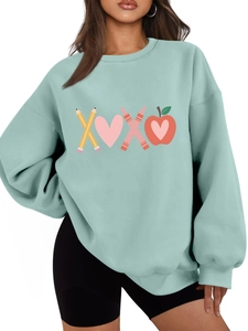 Detail of mint green oversized sweatshirt featuring creative XOXO pencil and heart graphic