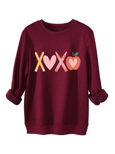 Detail of burgundy sweatshirt featuring XOXO pencil and heart graphic print with ribbed cuffs