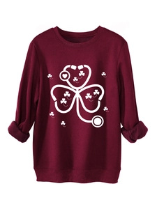 Detail of burgundy sweatshirt featuring a white stethoscope and shamrock heart print
