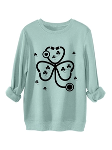 Detail of mint green sweatshirt featuring stethoscope shamrock print and ribbed cuffs