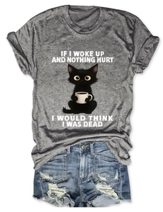 Flat lay of gray crew neck t-shirt with funny cat print and distressed denim shorts