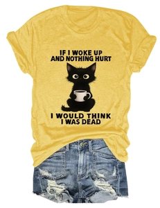 Flat lay of yellow cotton t-shirt with cat print and distressed blue denim shorts