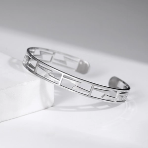 Bracelet jonc évidé en acier inoxydable argenté avec motifs géométriques et finition mate