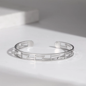 Détail du motif géométrique argenté sur le bracelet jonc en acier inoxydable