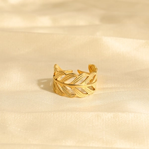 Eleganter goldener offener Blattring aus Edelstahl auf champagnerfarbenem Seidenstoff