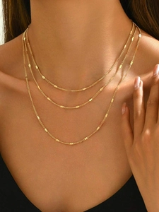 Vue détaillée d'un collier multicouche plaqué or 18 carats sur le cou d'un mannequin