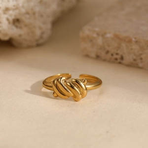 Minimalist double line twisted knot open ring in golden finish on stone background