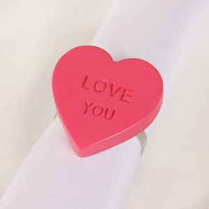 Rosafarbener herzförmiger Serviettenring mit LOVE YOU Gravur für den Tisch