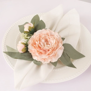 Primer plano de un servilletero de rosa rosa hecho a mano sobre un plato blanco