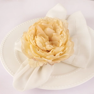 Elegante servilletero de rosa de seda melocotón en plato de porcelana blanca con perlas
