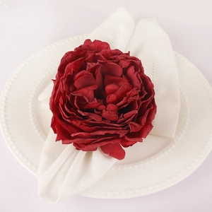 Deep red artificial peony flower napkin ring on white plate for wedding table decor