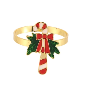 Close-up of golden Christmas napkin ring featuring candy cane and green holly details