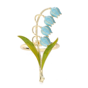 Detailed close-up of lily of the valley napkin ring with blue enamel and gold plating