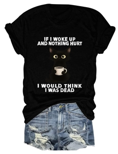 Detail of a black crew neck T-shirt with a cartoon cat print and distressed denim shorts