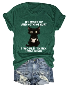 Close-up of a green t-shirt with a cartoon cat holding coffee and funny text print