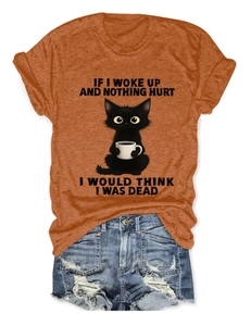 Detail of orange round neck t-shirt featuring black cat coffee print and denim shorts