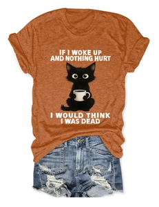 Detail of burnt orange t-shirt with black cat print and ripped denim shorts set