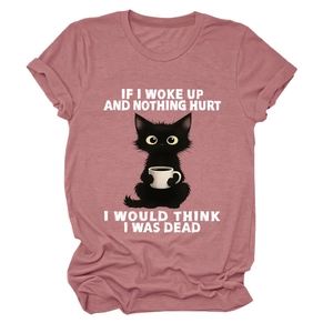 Detail of dusty rose T-shirt with funny black cat drinking coffee and witty quote print