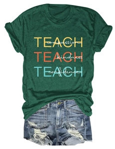 Détail du t-shirt vert foncé Teach Compassion avec imprimé coloré et short en jean vieilli