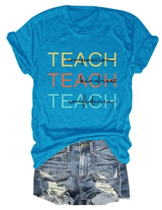 Détail du t-shirt bleu Teach Compassion avec un short en jean à bords effilochés