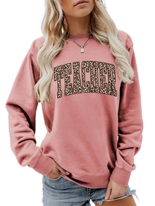 Close-up of pink crewneck sweatshirt featuring leopard print TEACHER text and ribbed cuffs