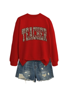 Detail of red crewneck sweatshirt with leopard print TEACHER text and denim shorts