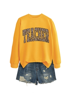 Close-up of mustard yellow crewneck sweatshirt featuring leopard print TEACHER lettering