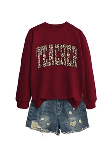 Detail of burgundy sweatshirt with leopard print TEACHER text and ripped denim shorts