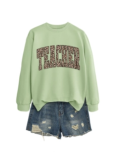 Close-up of light green leopard print teacher sweatshirt with distressed denim shorts